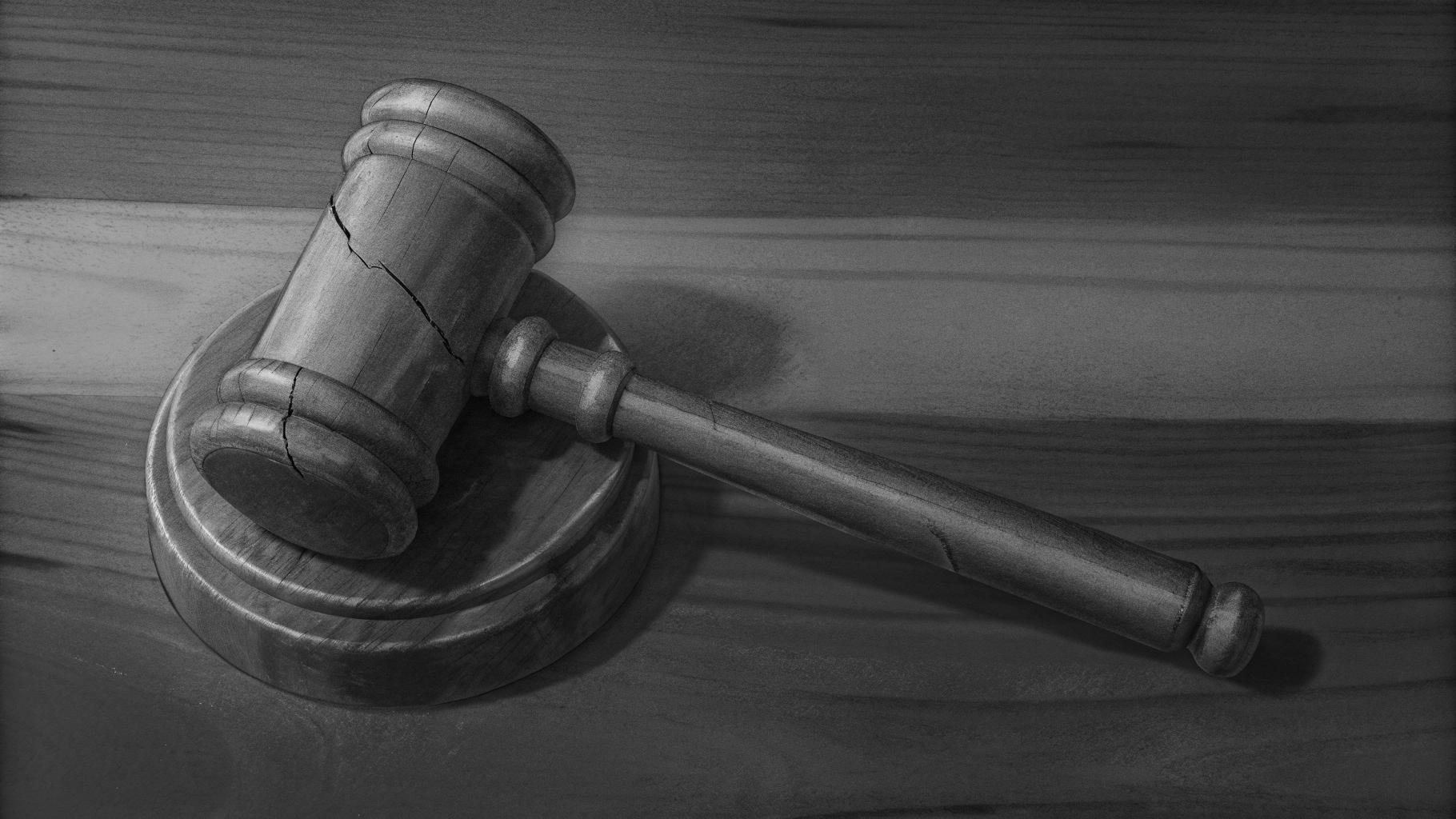 Illustration abstraite d'un marteau de juge brisé posé sur une table en bois sombre, symbolisant la fragilité de la justice, palette de gris et de charbon, sans texte ni logo.