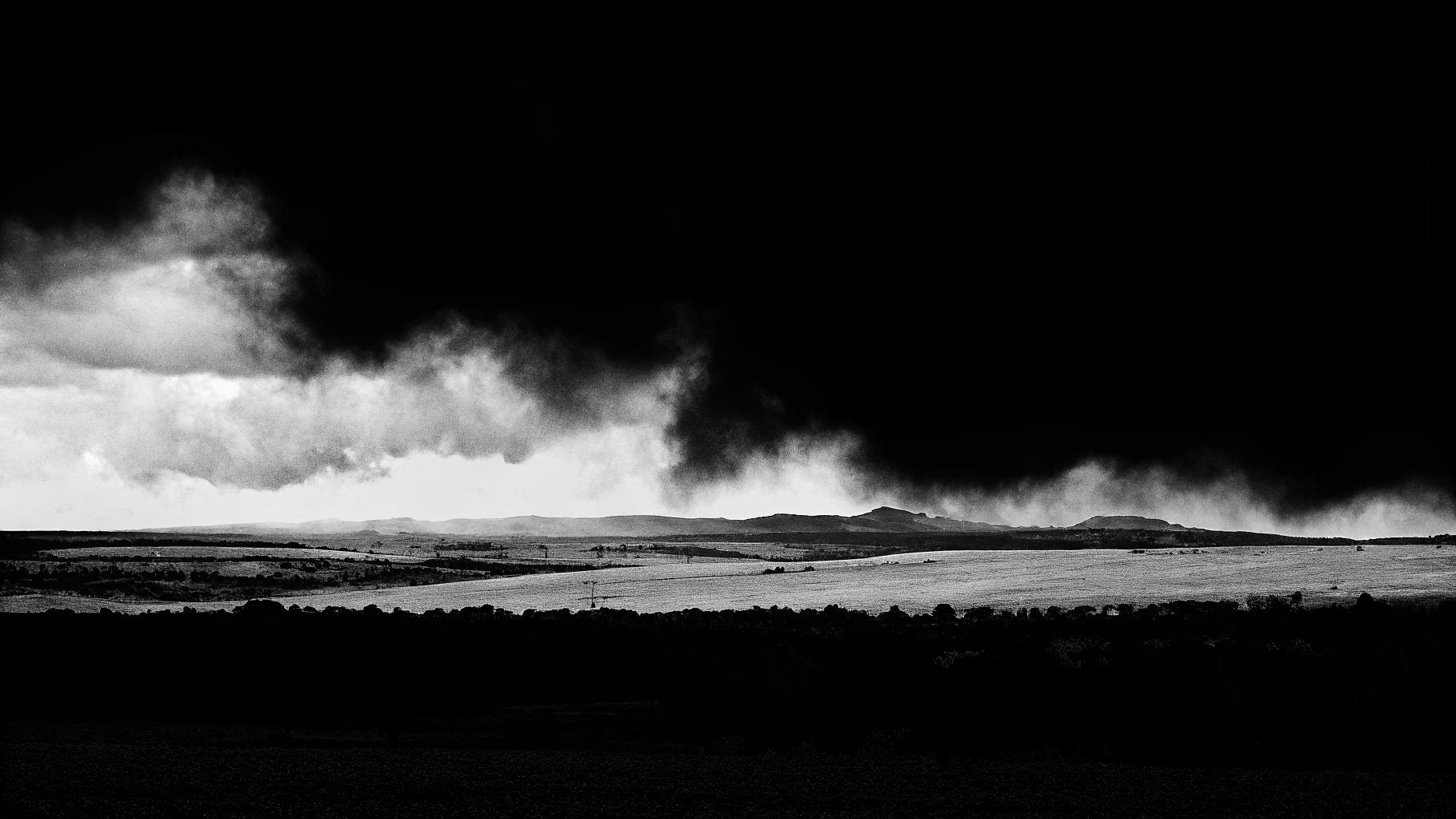 Illustration abstraite de canicules extrêmes sur un paysage français avec des nuages d'orage sombres à l'arrière-plan