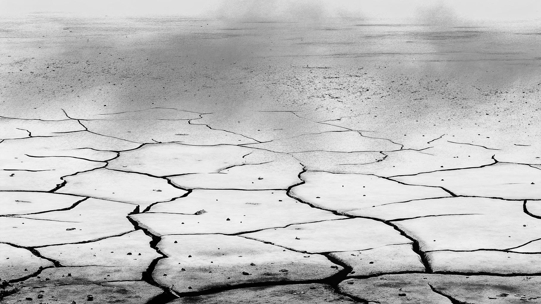 Illustration abstraite de la surface terrestre fracturée avec des vagues de chaleur ascendantes et de la glace en fusion, palette gris foncé et orange brûlé, sans texte, sans logo, sans visage, format paysage 3:2